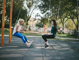 Girls on swings facing each other.