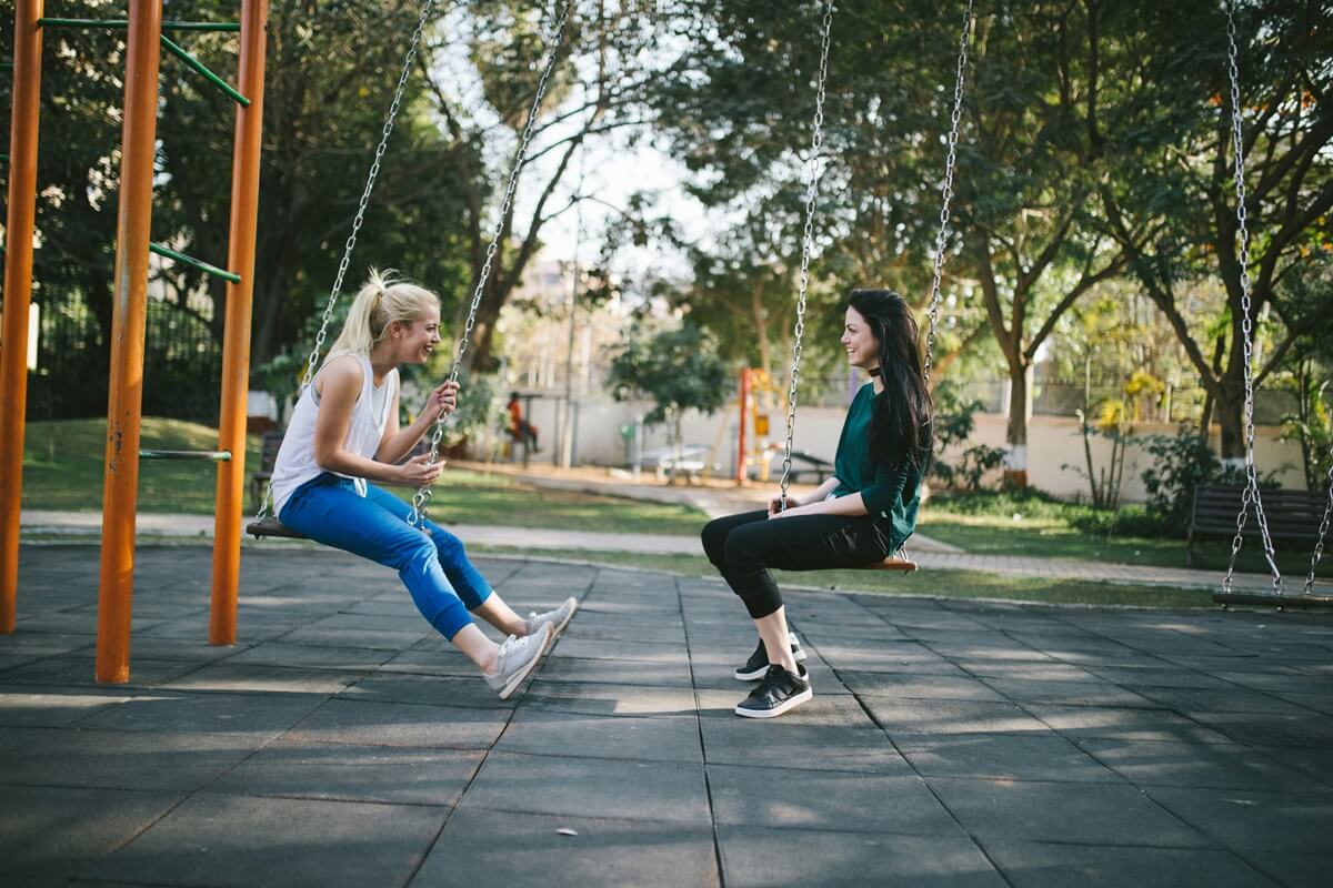 Girls on swings facing each other.