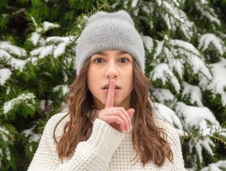 Woman in “quiet” pose with index finger raised