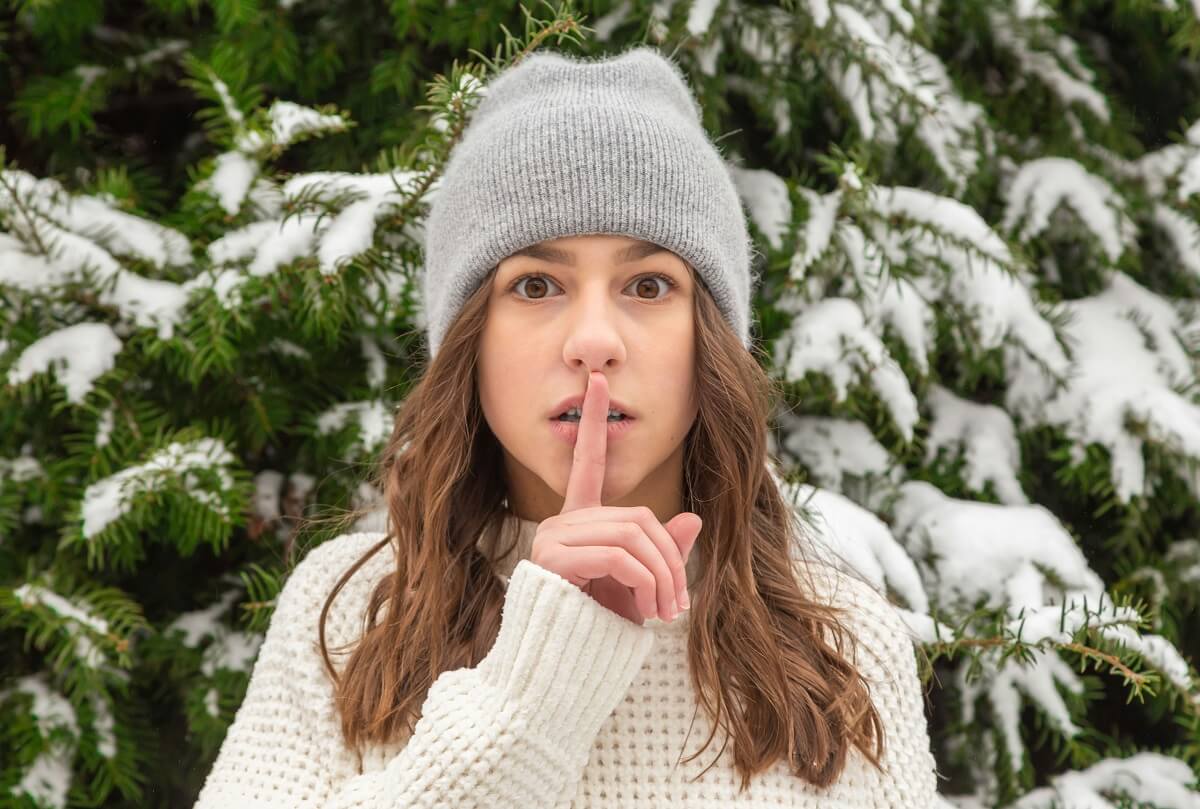 Woman in “quiet” pose with index finger raised